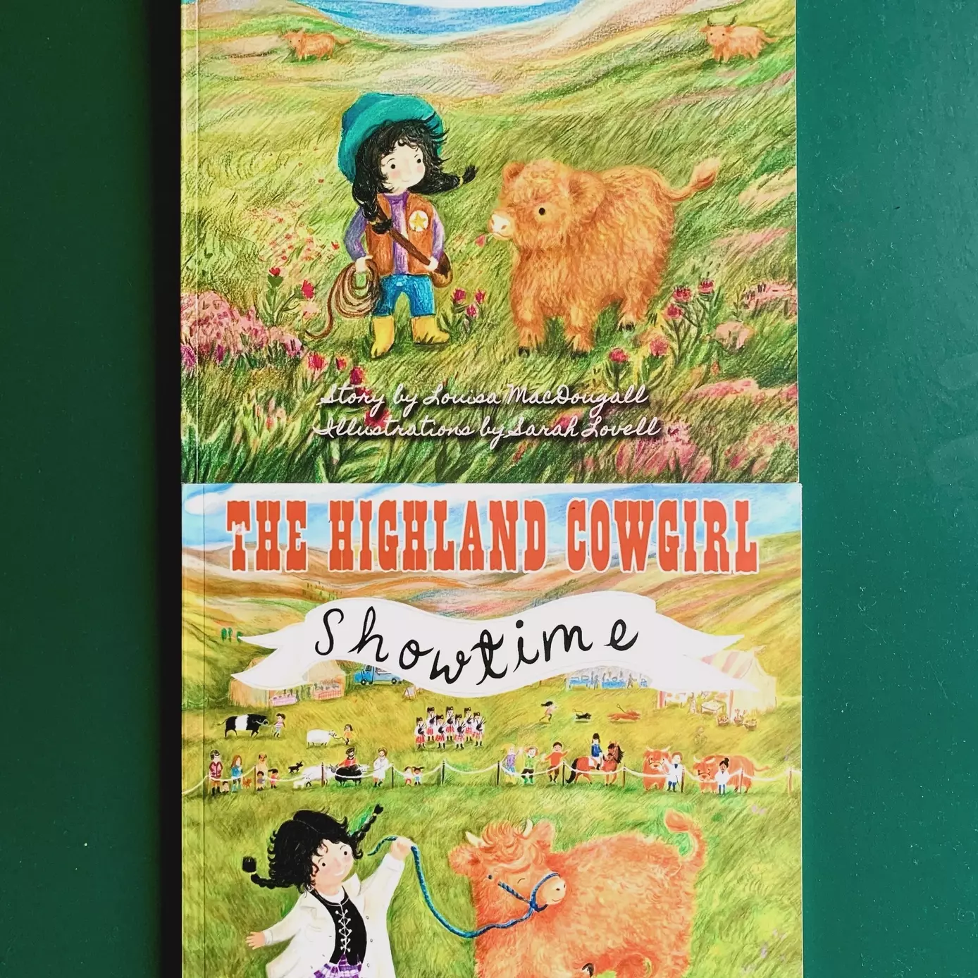 A photo of two picture books , both written by Louisa MacDougall, illustrated by Sarah Lovell and published by Foggie Toddle Books. The Highland Cowgirl and the Highland Cowgirl Showtime. Both books show an illustration of a girl with dark hair in plaits.